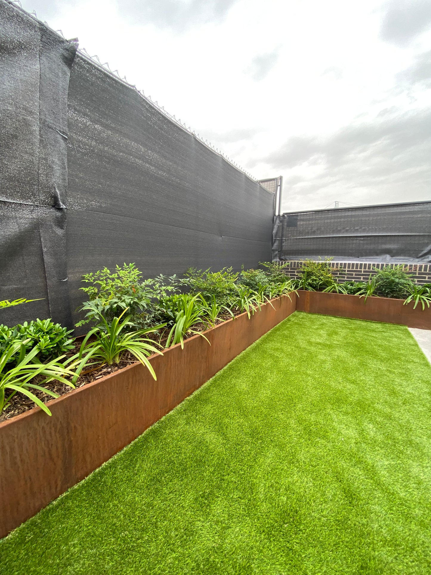 Alcorque de acero corten con plantas en jardin